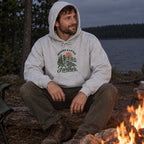 Man wearing the Wander a Little Farther Hoodie by a campfire at night