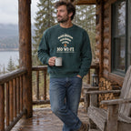 Man wearing the No Wi-Fi, Better Connection crewneck sweatshirt on a cabin porch with a mug