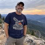 Man wearing the Wings Over the Ridges T-shirt outdoors